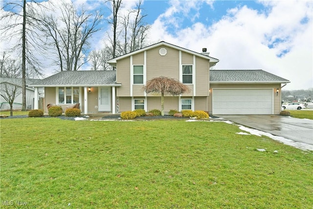 tri-level home with a garage and a front lawn