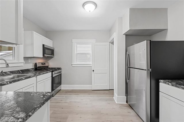 kitchen featuring sink, stainless steel appliances, light hardwood / wood-style floors, and white cabinets