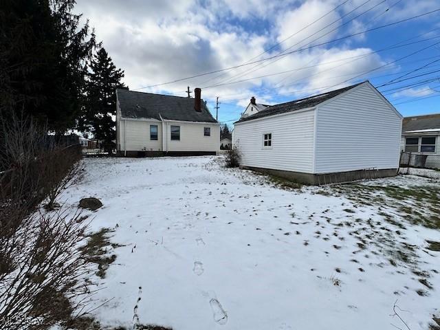 view of snow covered back of property