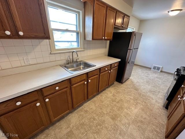 kitchen with sink, stainless steel fridge, and backsplash