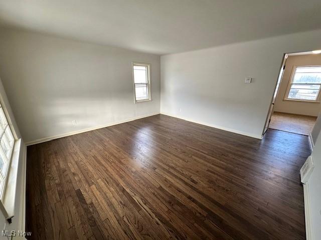 spare room featuring dark wood-type flooring and a wealth of natural light