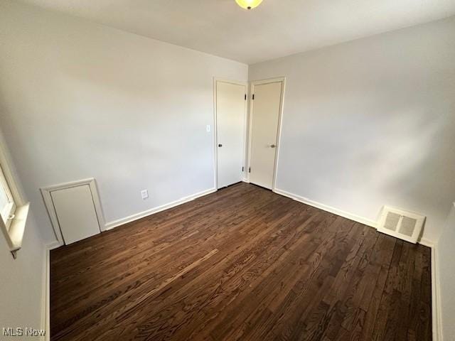 empty room with dark hardwood / wood-style floors