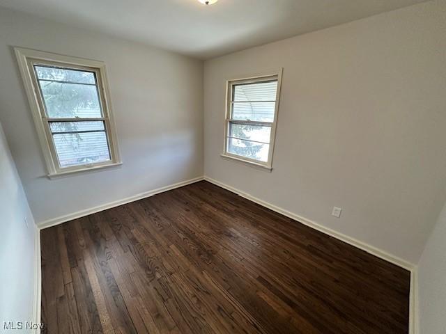 spare room with dark hardwood / wood-style flooring