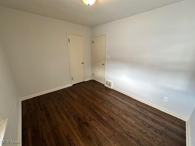 spare room with dark hardwood / wood-style flooring