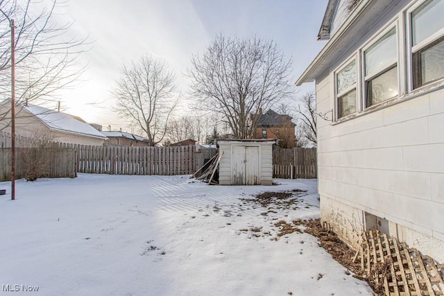 yard layered in snow featuring a shed