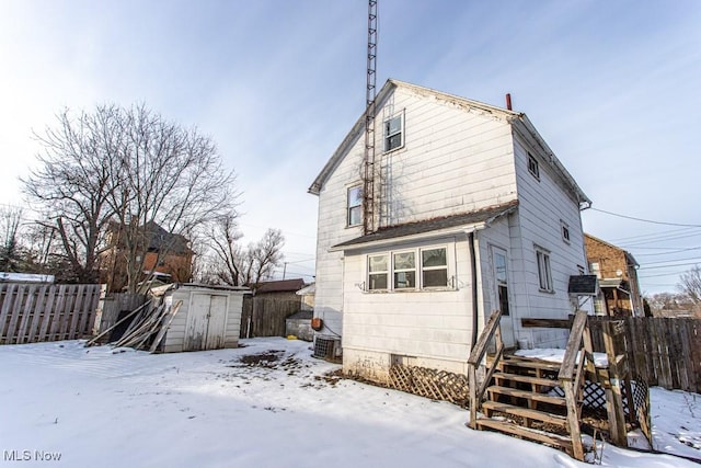 snow covered property with a storage unit