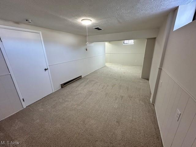 basement with light colored carpet and a textured ceiling