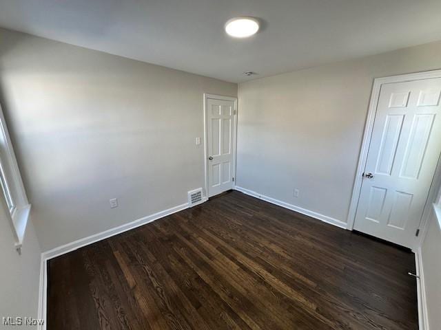 empty room with dark wood-type flooring