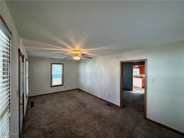 unfurnished bedroom featuring dark carpet and ceiling fan