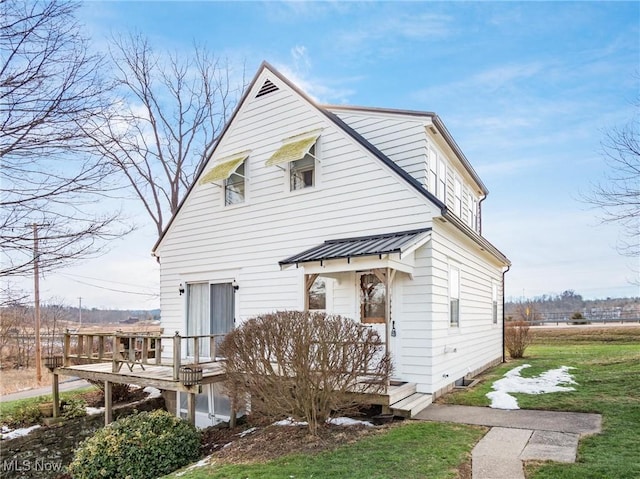 view of front of property with a deck and a front lawn