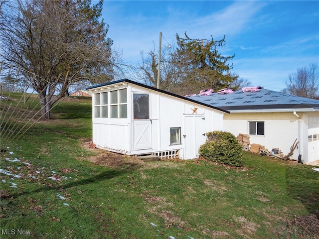 exterior space with a storage shed and a lawn