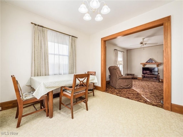 dining space with plenty of natural light, carpet flooring, and ceiling fan with notable chandelier