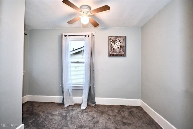 spare room with dark colored carpet, plenty of natural light, and ceiling fan