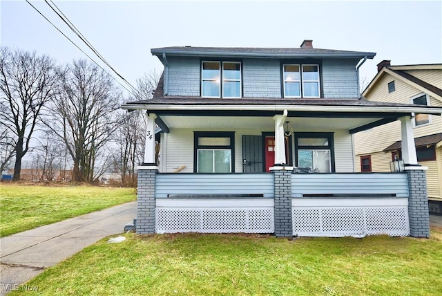 view of front of house with a front yard and covered porch