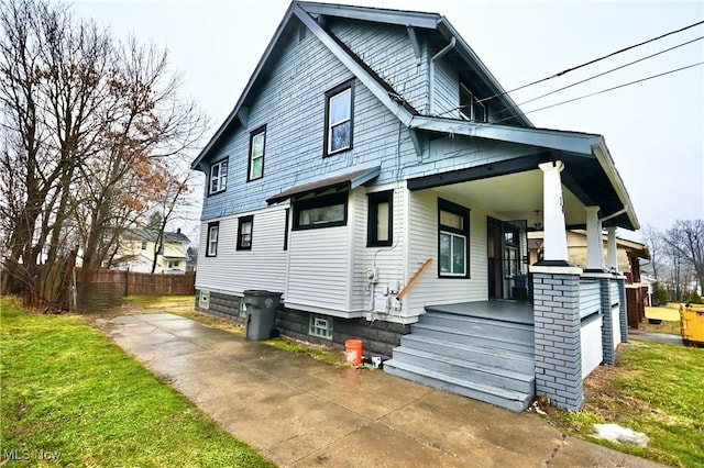 rear view of property with a porch and a garage