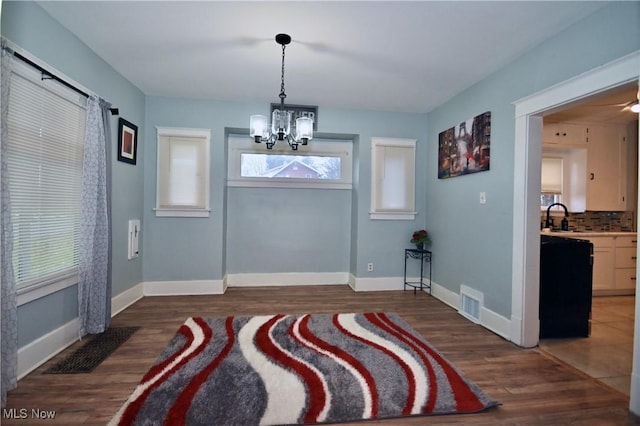 entrance foyer featuring sink, an inviting chandelier, and dark hardwood / wood-style flooring