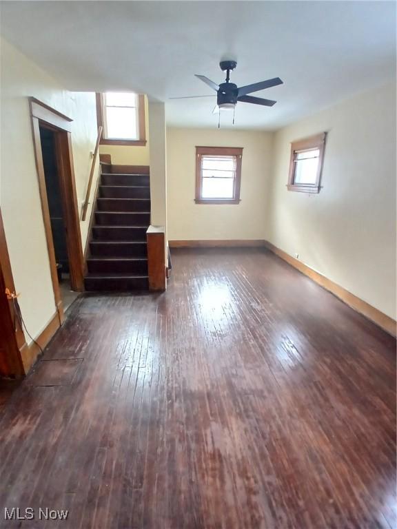 unfurnished living room with dark wood-type flooring and ceiling fan