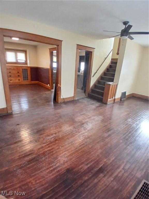 unfurnished living room with dark wood-type flooring and ceiling fan