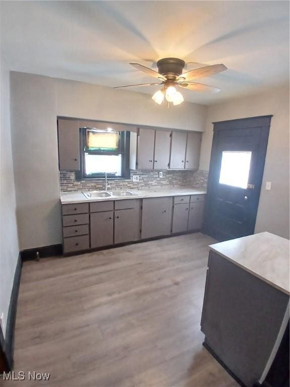 kitchen featuring tasteful backsplash, a healthy amount of sunlight, sink, and light hardwood / wood-style floors