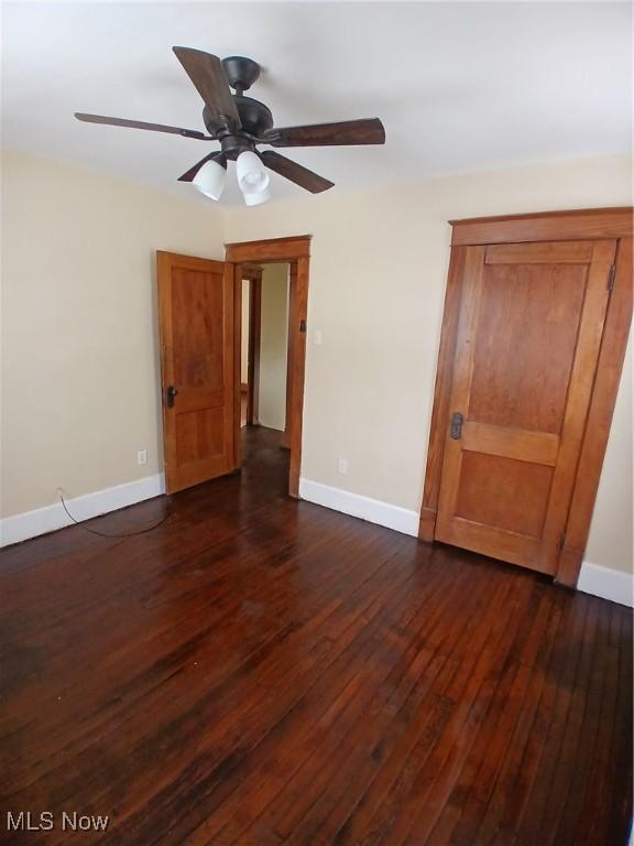 interior space featuring dark wood-type flooring and ceiling fan