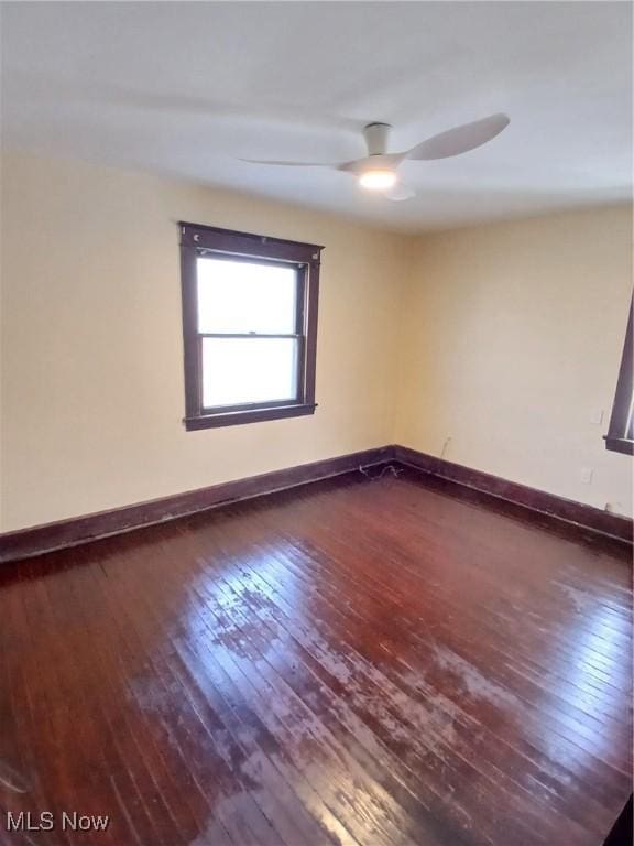 spare room with ceiling fan and dark hardwood / wood-style flooring