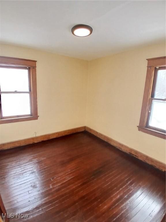 unfurnished room featuring dark wood-type flooring