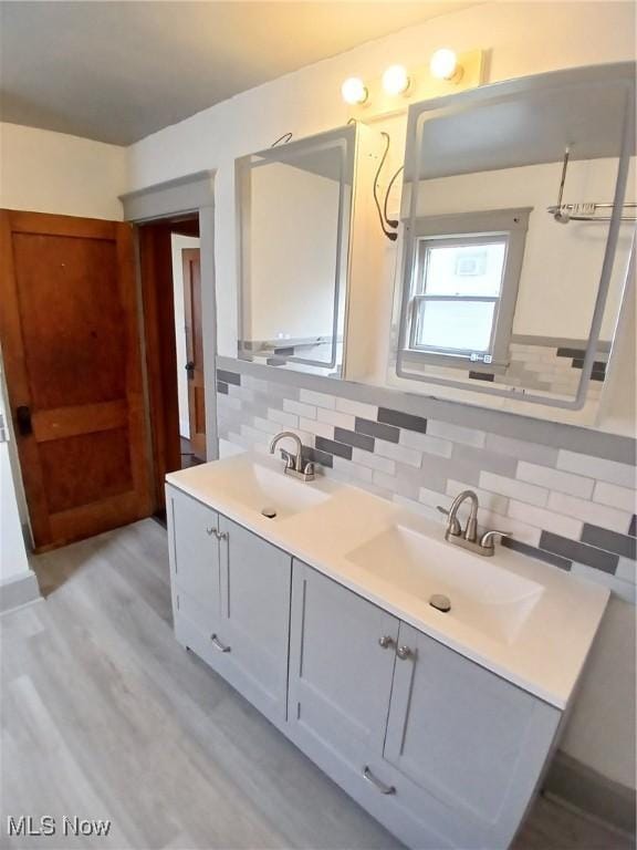 bathroom featuring vanity, hardwood / wood-style floors, and decorative backsplash