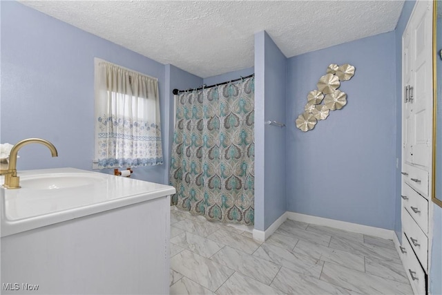 bathroom with vanity, curtained shower, and a textured ceiling