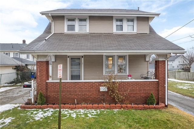 bungalow-style house with a front yard and covered porch