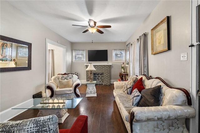 living room featuring dark hardwood / wood-style floors, a fireplace, and ceiling fan