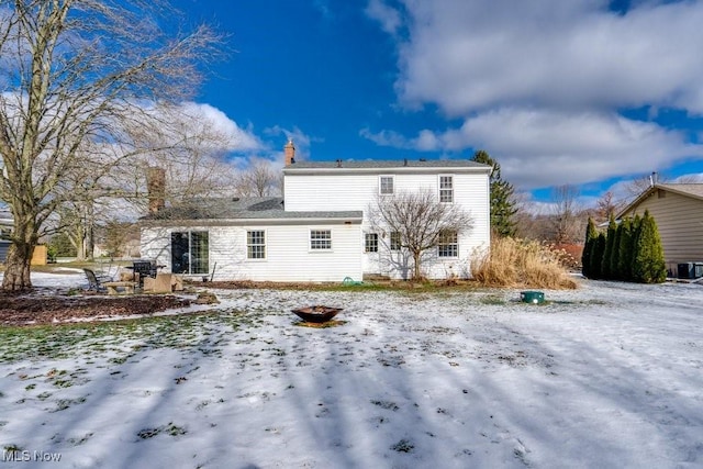 view of snow covered rear of property