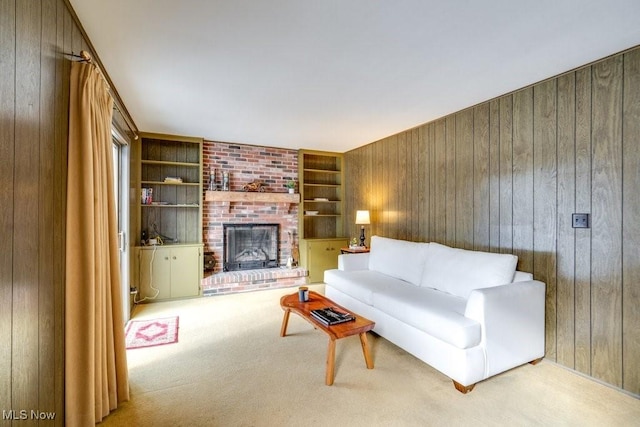 living room with light carpet, a brick fireplace, wooden walls, and built in features