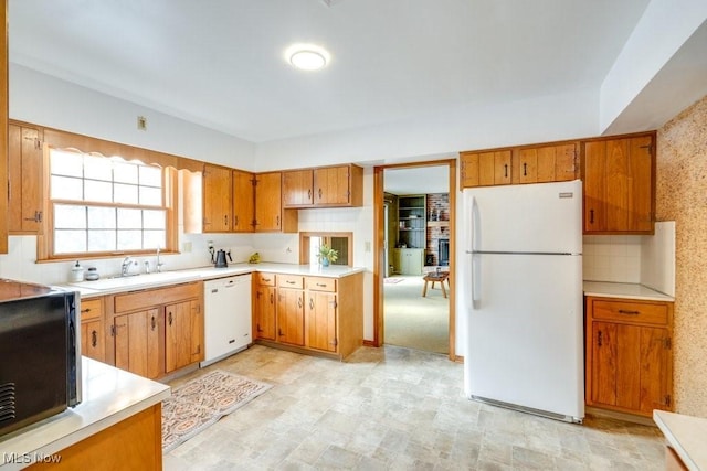 kitchen with white appliances, sink, and backsplash