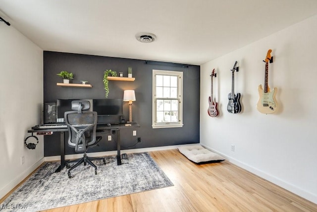 office featuring wood finished floors, visible vents, and baseboards