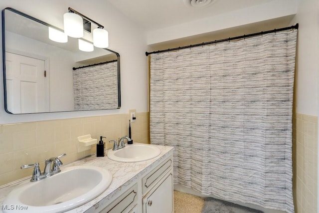 bathroom with a shower with curtain, vanity, and tile walls