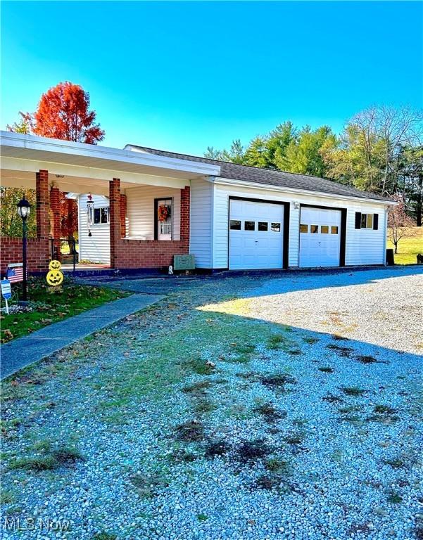 ranch-style home featuring a garage and covered porch