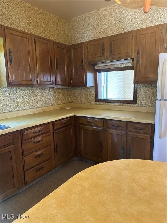 kitchen featuring backsplash, ceiling fan, and white fridge