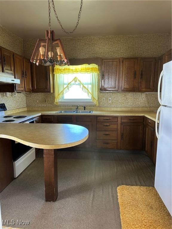 kitchen with hanging light fixtures, tasteful backsplash, sink, and white appliances