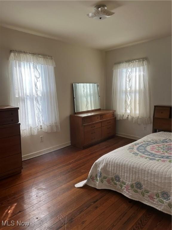 bedroom with dark hardwood / wood-style flooring