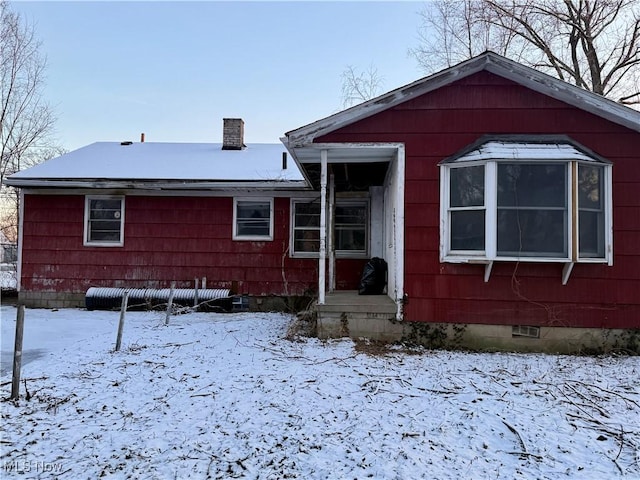 view of snow covered back of property