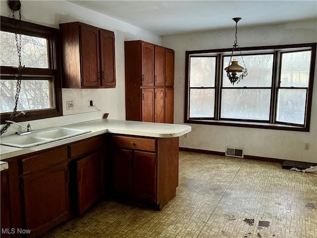 kitchen with pendant lighting, sink, and kitchen peninsula