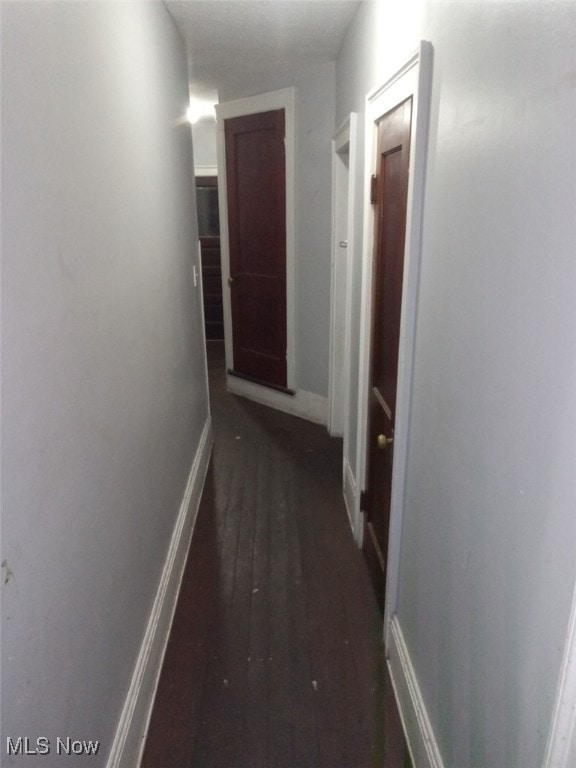 hallway with dark hardwood / wood-style flooring