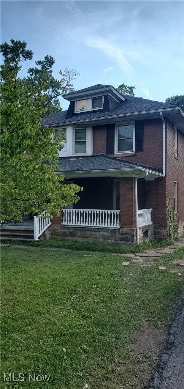 view of front of house with a porch and a front lawn