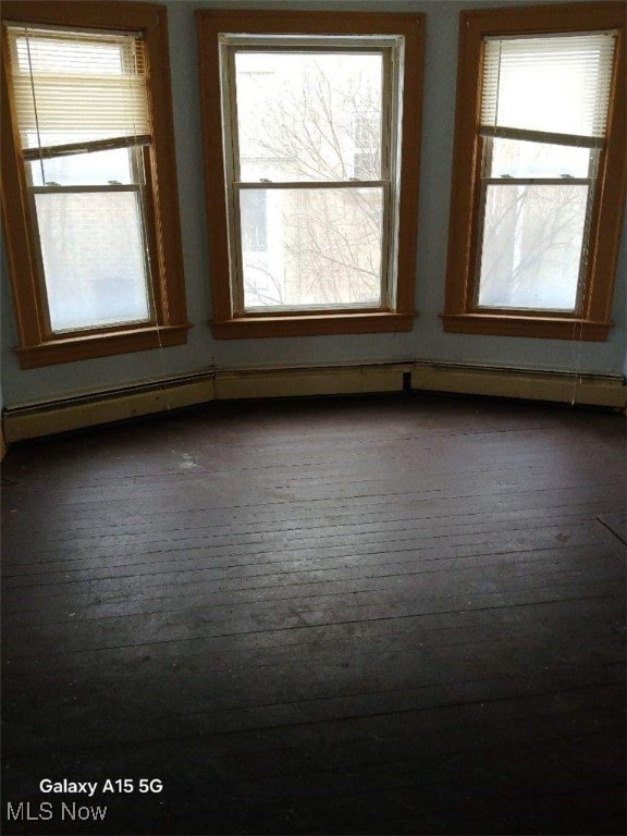 empty room featuring wood-type flooring and a healthy amount of sunlight