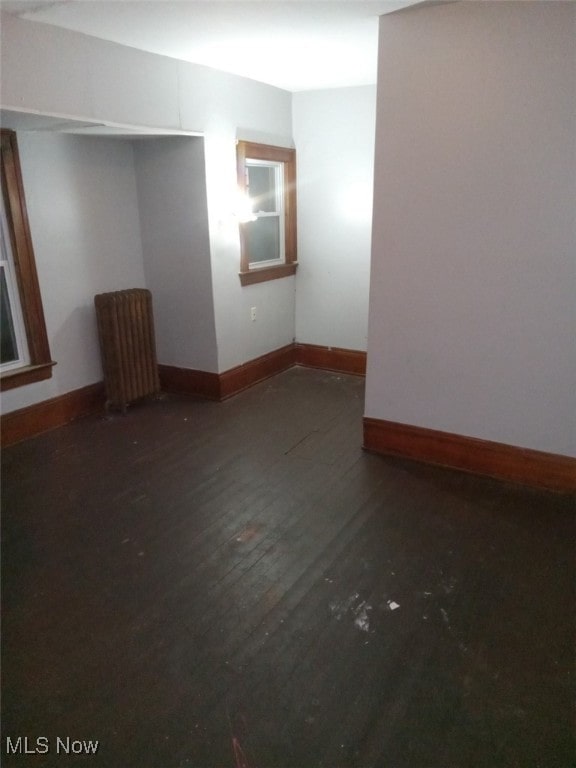 unfurnished room with dark wood-type flooring