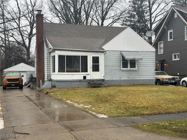 view of front of home with an outbuilding, a garage, and a front yard