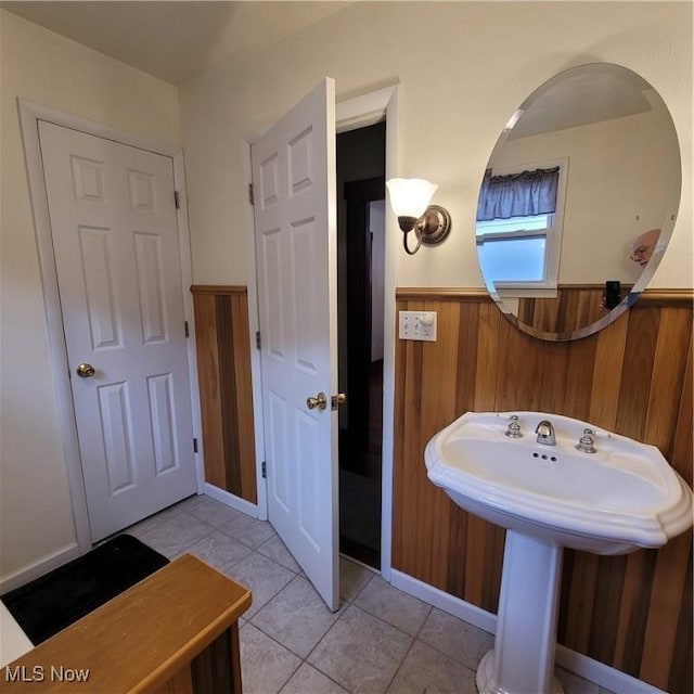 bathroom featuring tile patterned flooring and wooden walls