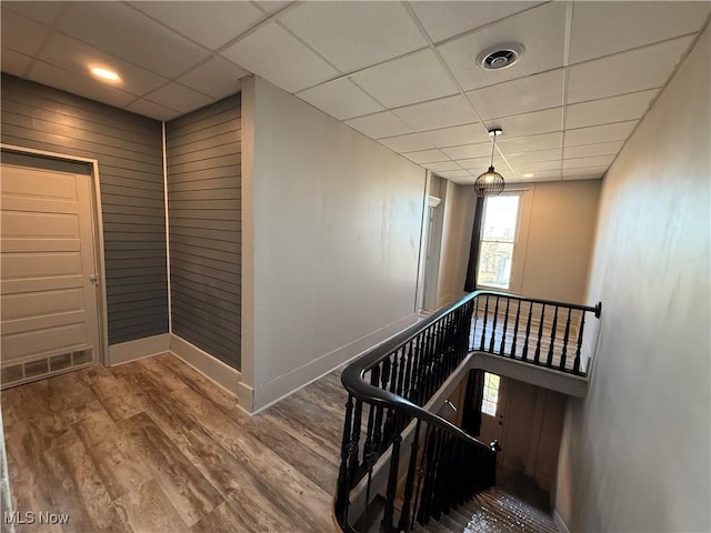 stairs featuring hardwood / wood-style flooring and a paneled ceiling