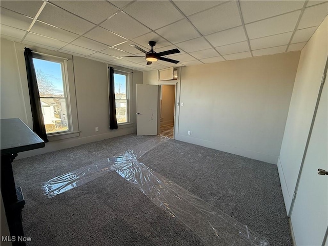 empty room with carpet flooring, a drop ceiling, and ceiling fan