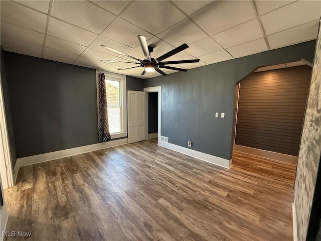 unfurnished room featuring ceiling fan, a paneled ceiling, and wood-type flooring